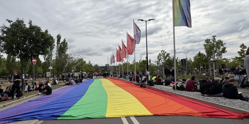 Vor der Messehalle wurde eine große Regenbogenflagge ausgebreitet.